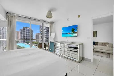 a white bedroom with a bed and a large window at Icon Brickell Residences in Miami