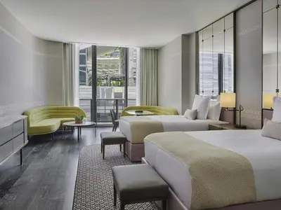 a hotel room with two beds and a couch at SLS LUX Brickell in Miami