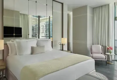 a bedroom with a large white bed and a chair at SLS LUX Brickell in Miami