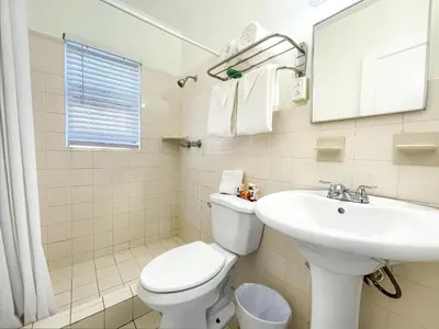 a bathroom with a white toilet and a sink at Ocean Villas in Hollywood