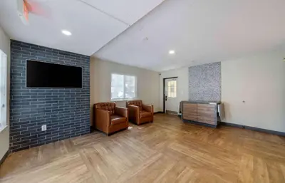 a living room with two chairs and a flat screen tv at Extended Stay America Suites - Miami - Airport - Doral in Miami