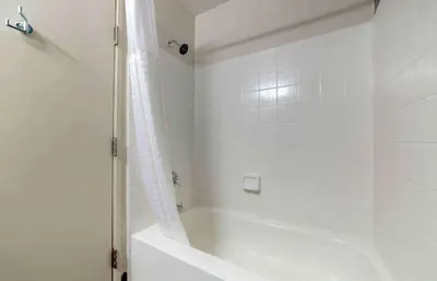 a white bathroom with a tub and a shower at Extended Stay America Suites - Miami - Airport - Doral in Miami