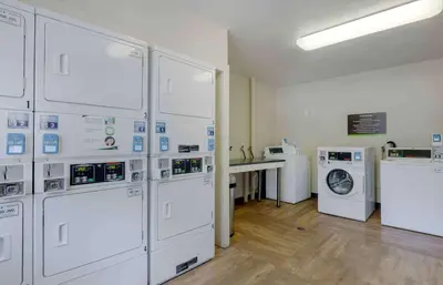 a laundry room with white washers and dryers at Extended Stay America Suites - Miami - Airport - Doral in Miami