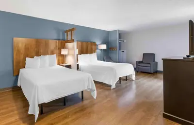 a hotel room with two beds and a chair at Extended Stay America Premier Suites - Fort Lauderdale - Convention Center - Cruise Port in Fort Lauderdale