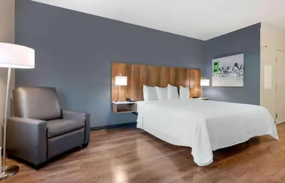 a bedroom with a large bed and a chair at Extended Stay America Premier Suites - Fort Lauderdale - Convention Center - Cruise Port in Fort Lauderdale