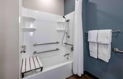 a bathroom with a tub and a shower with towels at Extended Stay America Premier Suites - Fort Lauderdale - Convention Center - Cruise Port in Fort Lauderdale