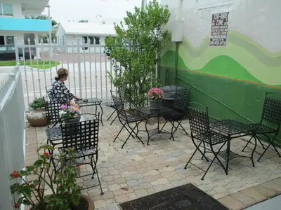 a woman sitting at a table in a patio at Shalimar Motel in Miami