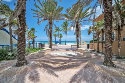 a walkway with palm trees and the beach at Laguna Blu Beach in Hollywood