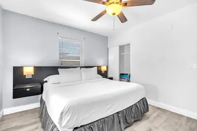 a bedroom with a large bed with a ceiling fan at Laguna Blu Beach in Hollywood