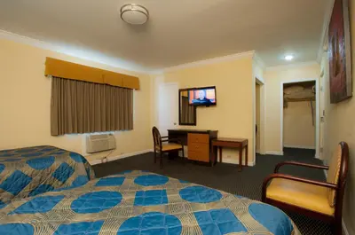 a hotel room with a bed and a desk and a tv at King Motel - Miami in Miami