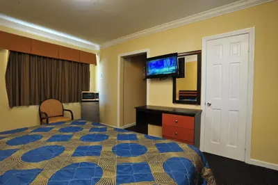 a hotel room with a bed and a flat screen tv at King Motel - Miami in Miami