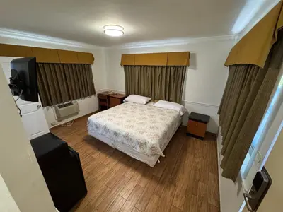 a hotel room with a bed and a television at King Motel - Miami in Miami
