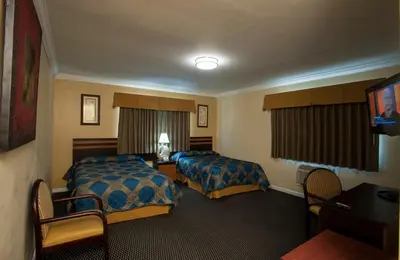 a hotel room with two beds and a television at King Motel - Miami in Miami