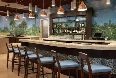 a bar with chairs and a counter with liquor bottles at DoubleTree by Hilton Miami Doral in Miami