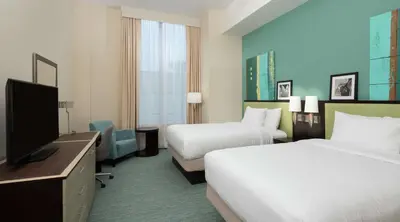 a hotel room with two beds and a flat screen tv at DoubleTree by Hilton Miami Doral in Miami