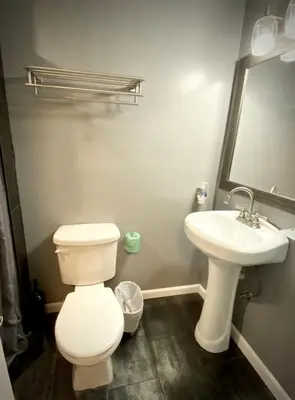 a bathroom with a white toilet and a sink at Sheridan Hostel in Dania Beach