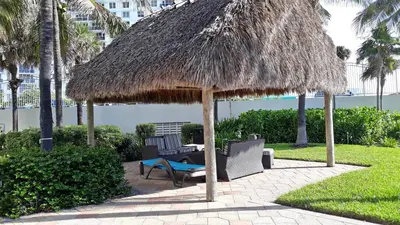 a patio with a straw umbrella and chairs and a table at THE TIDES 1 bedroom apt 10 floor WE ARE ON THE BEACH! in Hollywood