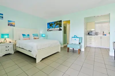 a bedroom with a white bed and a white tiled floor at Hollywood Beachside Boutique Suite in Hollywood