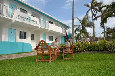 two people sitting in chairs in front of a hotel at Hollywood Beachside Boutique Suite in Hollywood