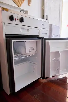 an open oven with its door open and a refrigerator at Migue´s Tiny Miami Alcove in Miami
