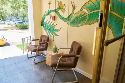 a room with two chairs and a wall with a mural at Migue´s Tiny Miami Alcove in Miami