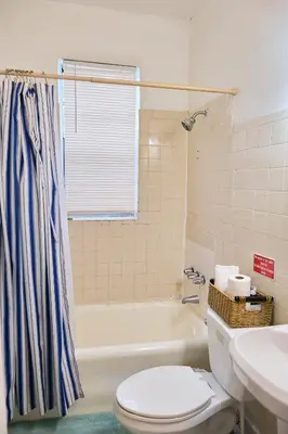 a bathroom with a toilet and a tub and a sink at The Marlin Rooster Apartments in Miami