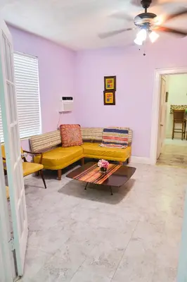 a living room with a yellow couch and a table at The Marlin Rooster Apartments in Miami