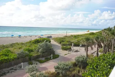 a view of the beach from the balcony of a condo at Crystal Beach Suites Miami Oceanfront Hotel in Miami Beach