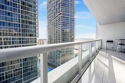 an apartment balcony with a view of a skyscraper at ICON Brickell residences in Miami