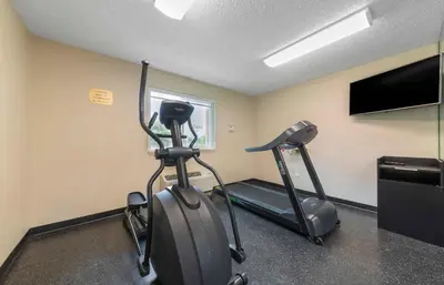 a room with a gym with a treadmill and a flat screen tv at Extended Stay America Premier Suites - Miami - Airport - Miami Springs in Miami