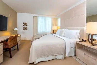 a bedroom with a large white bed and a desk at Oceanview Private Condo at 1 Hotel & Homes -906 in Miami Beach