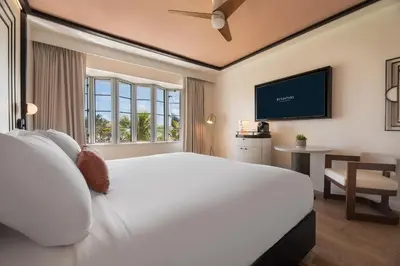 a bedroom with a large white bed and a desk at Eurostars Winter Haven Miami Beach in Miami Beach