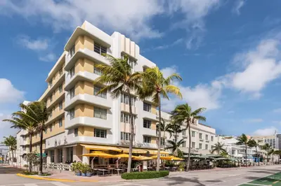 a tall white building with palm trees in front of it at Eurostars Winter Haven Miami Beach in Miami Beach