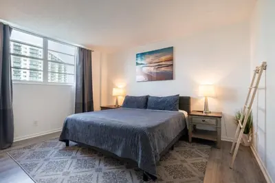 a bedroom with a bed and two lamps and a ladder at Ocean Reserve Condominium in Miami Beach