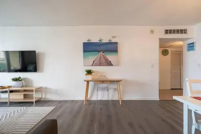 a living room with a table and a television at Ocean Reserve Condominium in Miami Beach