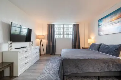 a bedroom with a bed and a flat screen tv at Ocean Reserve Condominium in Miami Beach