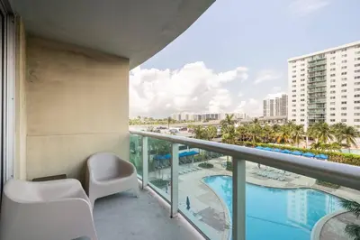 a balcony with a view of the pool and palm trees at Ocean Reserve Condominium in Miami Beach