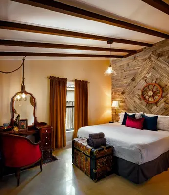 a bedroom with a bed and a table and a chair at The Captain's Quarters - Home & Guesthouse in Fort Lauderdale