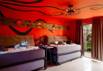 two beds in a room with red walls at The Captain's Quarters - Home & Guesthouse in Fort Lauderdale
