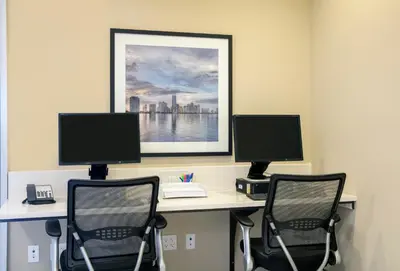 an office with two desks with two computer monitors at Candlewood Suites - Miami Exec Airport - Kendall by IHG in Kendall