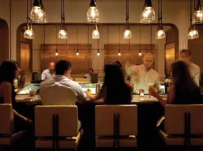 a group of people sitting at a restaurant at Signature Suite at Four Seasons Residences - Limited Time Offer in Miami