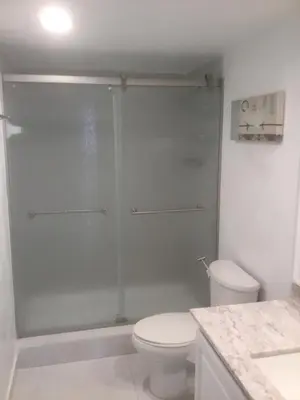 a bathroom with a shower with a toilet and a sink at Ocean Reserve Sunny Isles in Miami Beach