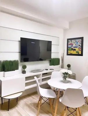 a living room with a table and chairs and a tv at 2 Bedroom Ocean Drive Newly Renovated in Miami Beach