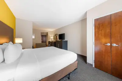 a bedroom with a large bed and a wooden door at Comfort Suites Miami Airport North in Miami