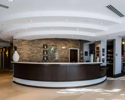 a lobby with a reception counter and a brick wall at Comfort Suites Miami Airport North in Miami