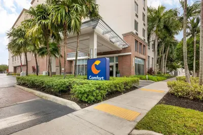 a sign in front of a building with a courtyard at Comfort Suites Miami Airport North in Miami