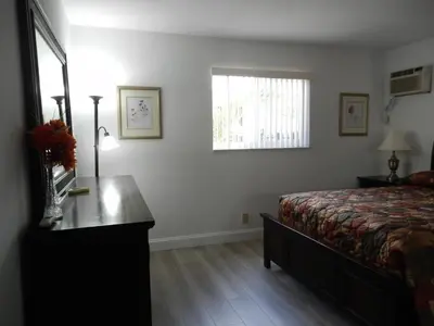 a bedroom with a bed and a desk and a window at Shell Motel Hollywood in Hollywood