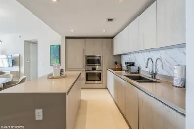 a kitchen with stainless steel appliances and wooden cabinets at Lyfe Residence Building - Private apts over the beach in Hollywood