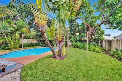 a palm tree and a swimming pool in a yard at Casa del Ojo- Heated Pool - 3 King beds in Fort Lauderdale