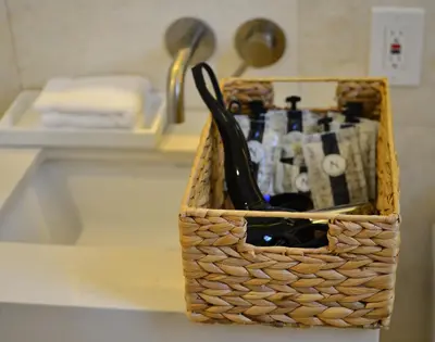a basket on a counter with bottles and utensils at Hotel St. Michel in Miami